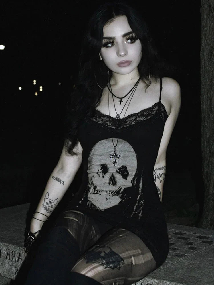 Woman wearing black emo dresses for women with skull print and layered necklaces sitting outdoors at night