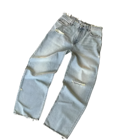 Light blue affordable streetwear baggy denim jeans with distressed details and frayed hems