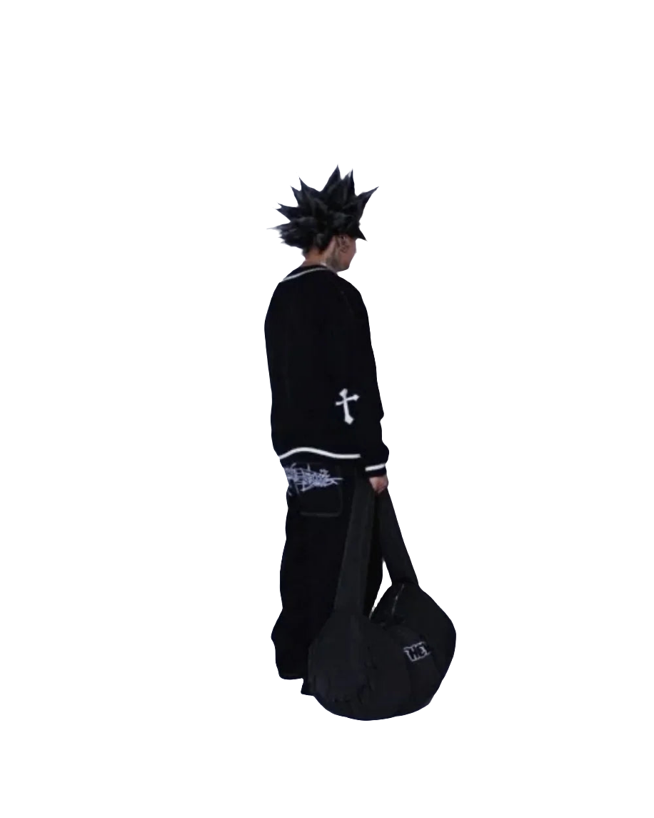 Person wearing black baggy jeans with graphic design holding a black duffel bag facing sideways