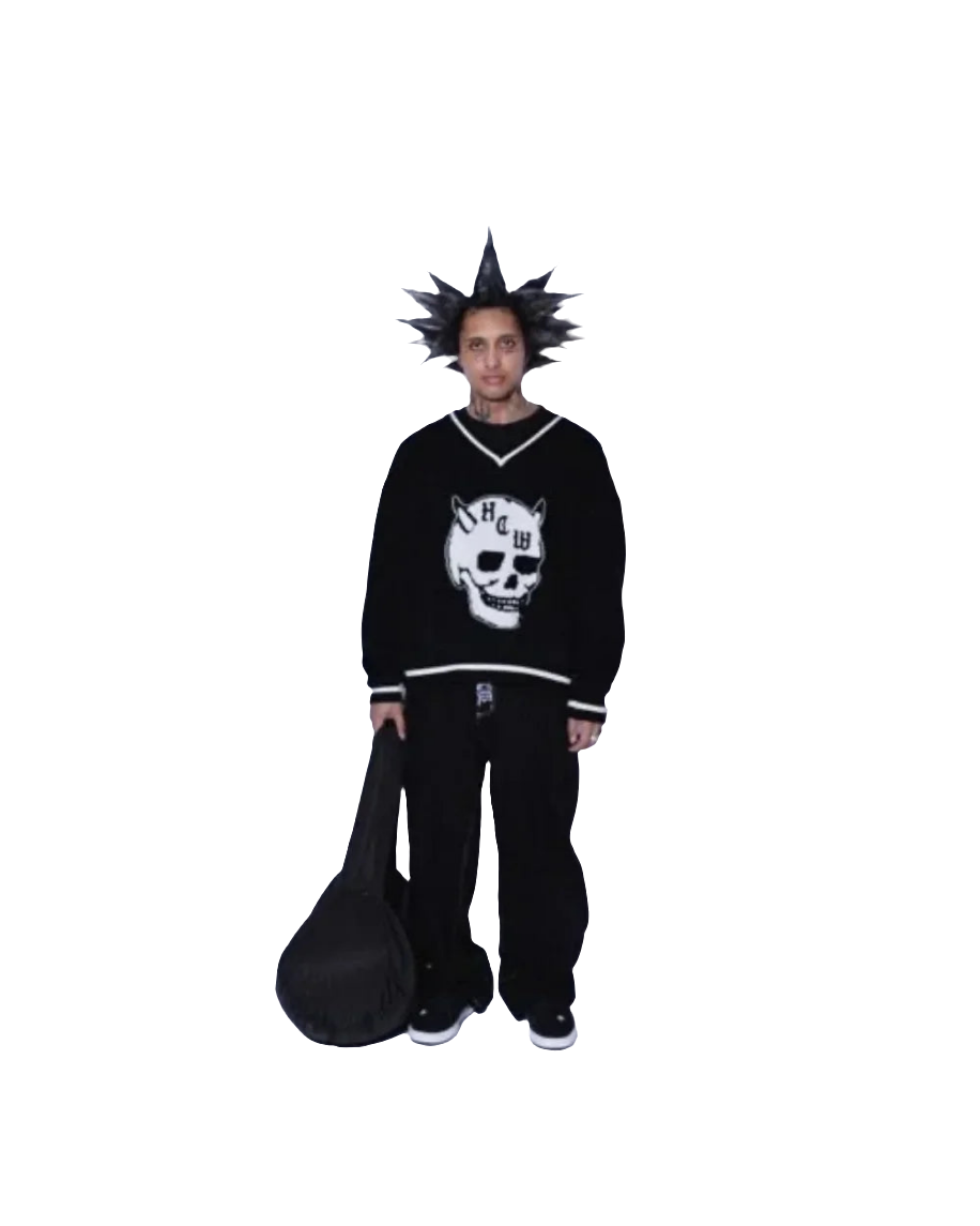 Person wearing baggy jeans with graphic design and black skull sweater holding a black bag